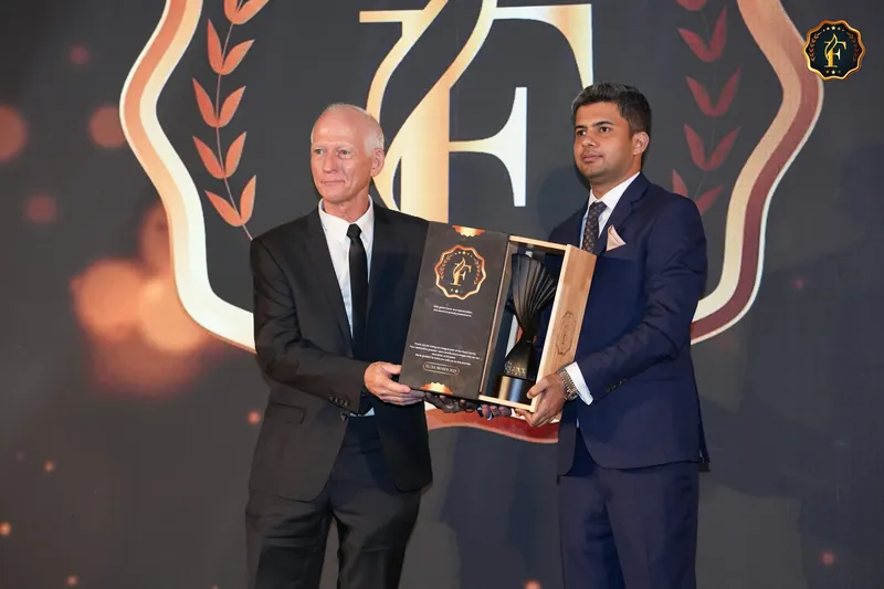 Robbie McKenzie on stage at the 2025 FLUXX Awards, receiving the award trophy in its presentation case